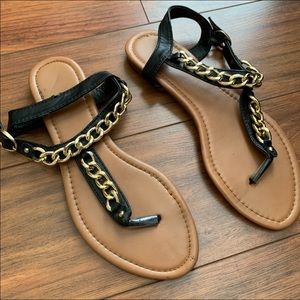 Black sandals with gold metal chain detail